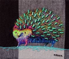 an embroidered hedgehog on a black and white checkered background with green, blue, yellow, pink, orange, and purple sprinkles