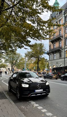 a black car is parked on the side of the road in front of some buildings