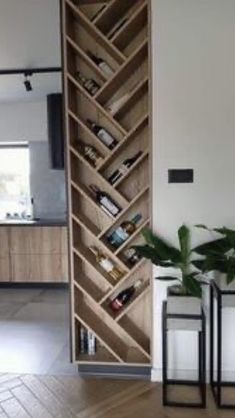 an open book shelf sitting on top of a hard wood floor next to two planters