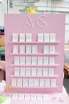 there is a pink display with greeting cards on the shelf and other items in front of it