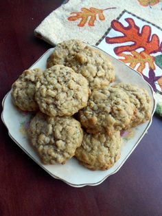 a plate full of oatmeal cookies sitting on a table next to a napkin