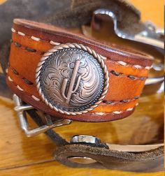 #46 - Hand-crafted, one-of-a-kind leather cuff bracelet. Hand-stitched, stained and styled with bronze cactus concho and snap closure. Cuff is 1.5 inches at the concho and tapers to 1 inch at snap. Fits up to a 7.5-inch wrist. Leather Cuff Bracelet, Western Leather, Leather Cuffs Bracelet, Leather Cuffs, Hand Stitched, Hand Stitching, Snap Closure, Cuff Bracelet, Leather Bracelet