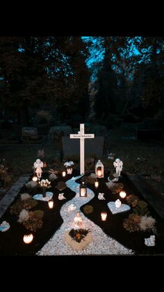 a cemetery with candles and crosses lit up at night