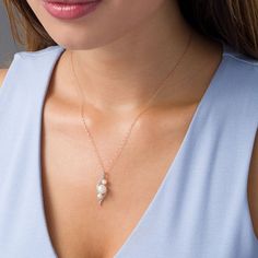 Graceful and glamorous, this pearl and diamond pendant takes your look to the next level. Fashioned in precious 10K rose gold, this alluring linear design features a luminous 8.0-8.5mm freshwater cultured pearl flanked by 4.0-4.5mm freshwater cultured pearls-all set diagonally between sculpted bypassing ribbons lined with sparkling petite diamonds. Radiant with 1/8 ct. t.w. of diamonds and a brilliant buffed luster, this three-stone pendant suspends along a 17.0-inch rope chain that secures with Anniversary Rose Gold Necklace With Pearl Pendant, Rose Gold Akoya Pearl Pendant Jewelry, Rose Gold Pearl Necklace With Charm For Anniversary, Rose Gold Pearl Charm Necklace For Anniversary, Rose Gold Pearl Drop Necklace For Anniversary, Anniversary Rose Gold Pearl Necklace With Charm, Anniversary Rose Gold Pearl Drop Necklace, Elegant Rose Gold Pearl Drop Necklace, Rose Gold Akoya Pearl Necklace With Pearl Drop