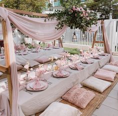 a table set up with pink and white decorations