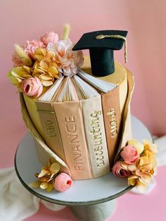 a graduation cake decorated with books and flowers