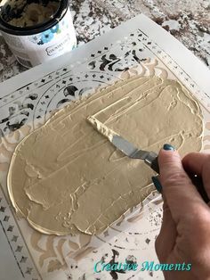 someone is spreading icing on a cake with a knife in front of the frosting