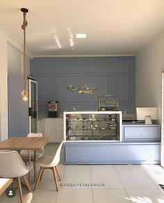 the interior of a restaurant with blue walls and white tile flooring, along with wooden tables and chairs