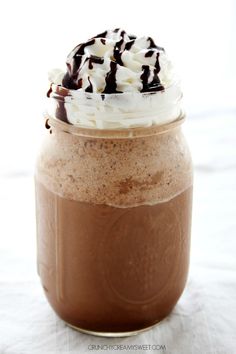 a chocolate drink with whipped cream and chocolate drizzled on top in a mason jar