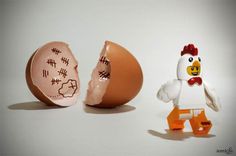 an egg shell and toy chicken are next to each other