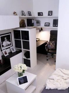 a room with white furniture and pictures on the wall, along with a black chair