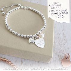 "Our beautiful range of engraved handwriting jewellery makes a beautiful dedication to a loved one, all it takes is a photo of their handwriting for our engraving team to work from. This beautiful silver bracelet combines a silver heart charm, perfect for engraving a name or a short message from a handwriting sample, alongside a beautiful pearl and a dainty silver puffed heart charm. The sterling silver heart charm measures 12mm across the front of the heart and sits centrally on a sterling silv Silver Heart Bracelet For Gift, Silver Jewelry With Engraved Text For Valentine's Day, Elegant Hand Stamped Silver Name Bracelet, Engraved Heart Bracelet In Sterling Silver, Sterling Silver Heart Bracelet For Wedding And Mother's Day, Engraved Heart Bracelet In White Gold Sterling Silver, Elegant Bracelets With Heart Charm For Personalized Gift, Engraved Sterling Silver Heart Bracelet In White Gold, Anniversary Engraved Sterling Silver Name Bracelet