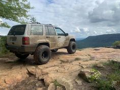 a jeep parked on top of a rocky hill