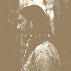 a man with long hair wearing a denim jacket and the words forever written on it