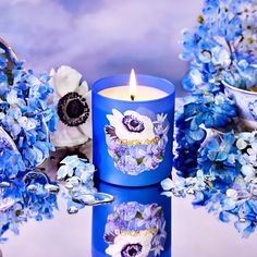 a blue candle sitting next to some flowers