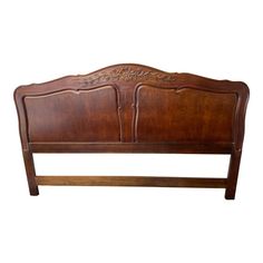 a wooden headboard with carvings on the top and bottom panel, against a white background