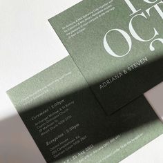 two green and white business cards sitting on top of each other