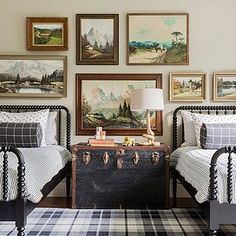 a bedroom with two twin beds and pictures on the wall above them in various frames