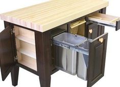 a kitchen island with two trash cans under it