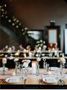 the table is set with white flowers and candles