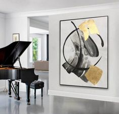 a grand piano sits in front of a painting on the wall