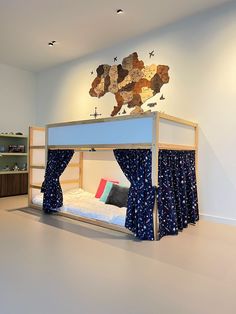 a bunk bed with curtains on it in a room that has white walls and flooring