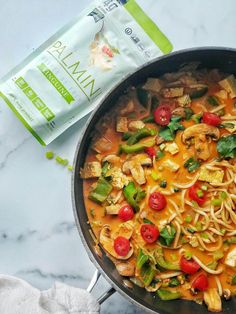 a pan filled with noodles and vegetables next to a bag of pasta