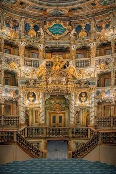 an ornately decorated auditorium with blue seats