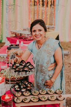 a woman standing in front of a table filled with food