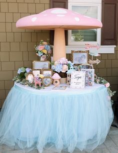 there is a table with pictures on it and a mushroom shaped umbrella in the background