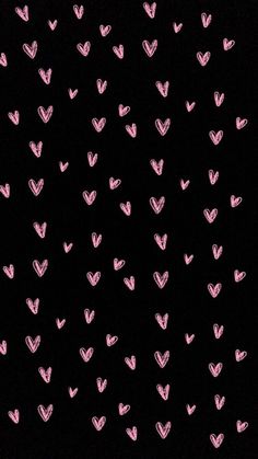 pink hearts are drawn on black paper