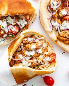 three pita sandwiches with chicken, tomatoes and onions