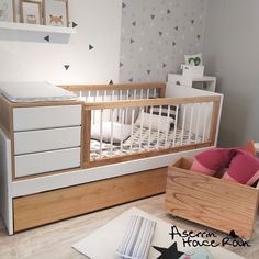 a baby's room with a crib, dresser and bed in the corner