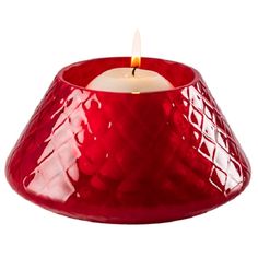 a red candle holder with a lit candle in the middle and a white background behind it