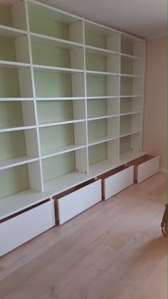 empty bookshelves in an empty room with hard wood flooring