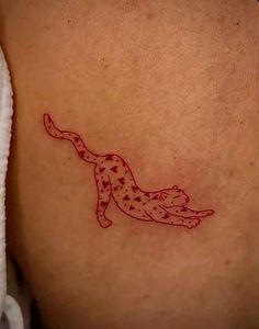 a cat tattoo on the back of a woman's left side ribcage