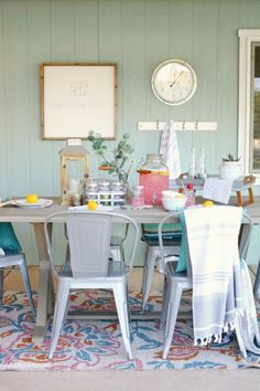 a dining room table with chairs and a clock on the wall