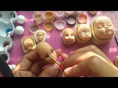 someone is painting faces on clay with acrylic paint and some other crafting supplies