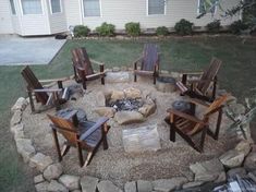 an outdoor fire pit with chairs around it