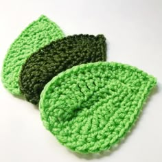 two green crocheted leaves sitting next to each other