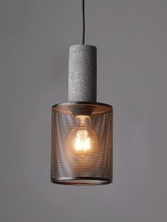 a light that is hanging from a wire on the ceiling in a room with grey walls