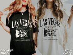 two beautiful women standing next to each other wearing t - shirts with las vegas designs on them