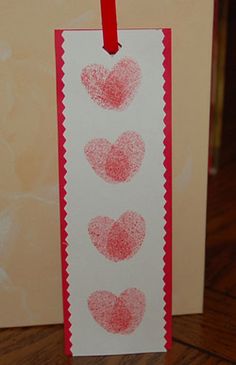 a card with three hearts drawn on it and a red string hanging from the front