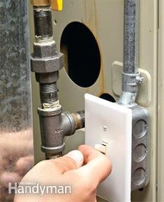 a person is adjusting the light switch on a water heater