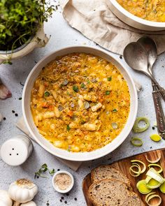 two bowls filled with soup next to slices of bread