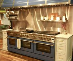 a kitchen with an oven, stove and shelves on the wall in it's center