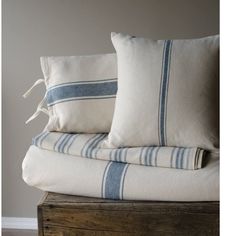 two white and blue striped pillows stacked on top of each other