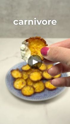 a hand holding a piece of food on top of a blue plate