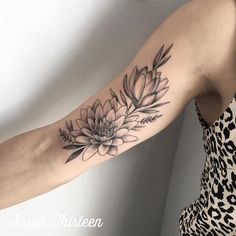 a woman's arm with a flower tattoo on the left side of her arm