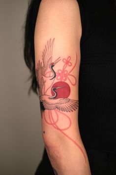 a woman's arm with a tattoo on it and an image of a bird